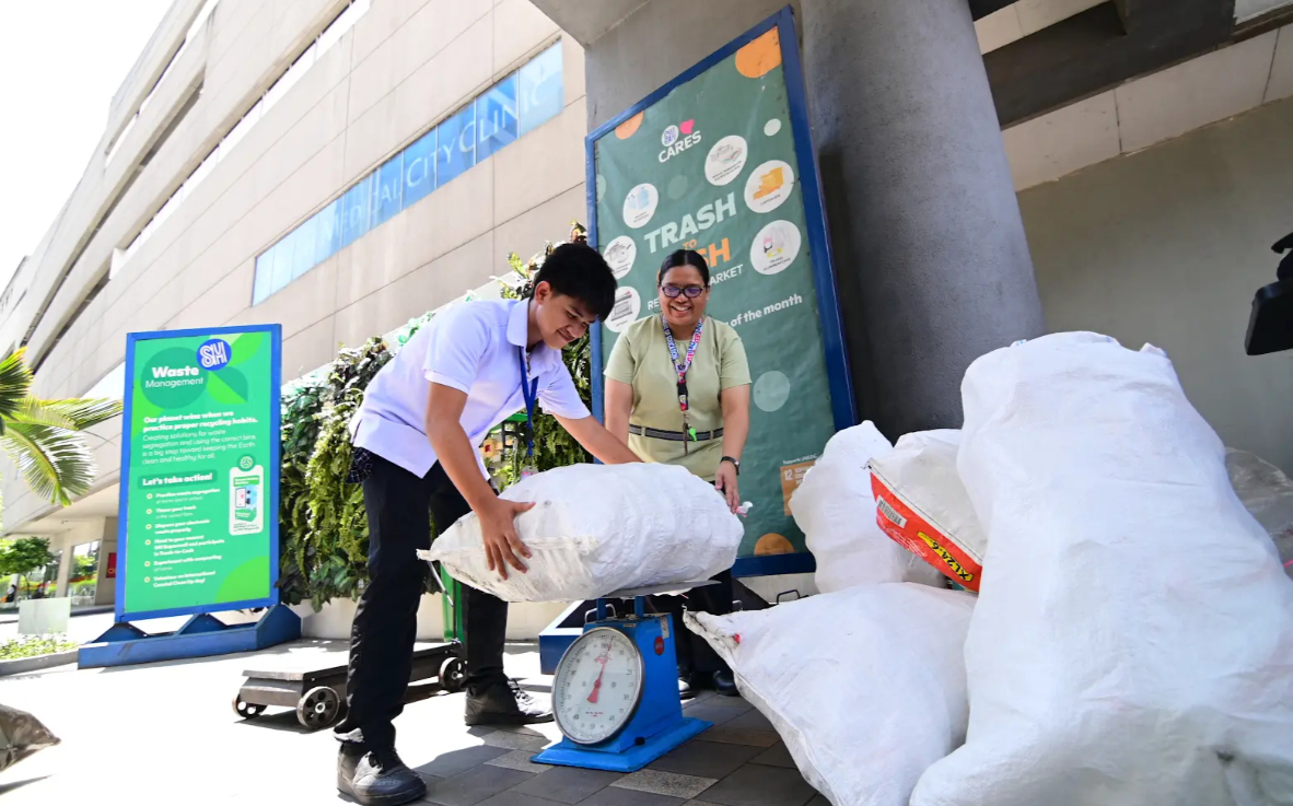 A student weighs recyclables with his teacher at SM Cares’ Trash to Cash, proving that every small effort adds up to a greener future.